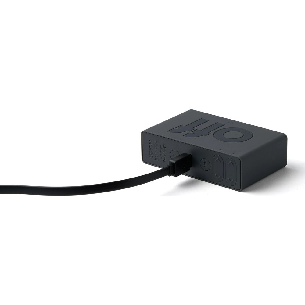 Ein graues rechteckiges Lexon Flip Mini Gerät mit einem schwarzen Kabel, das angeschlossen ist.