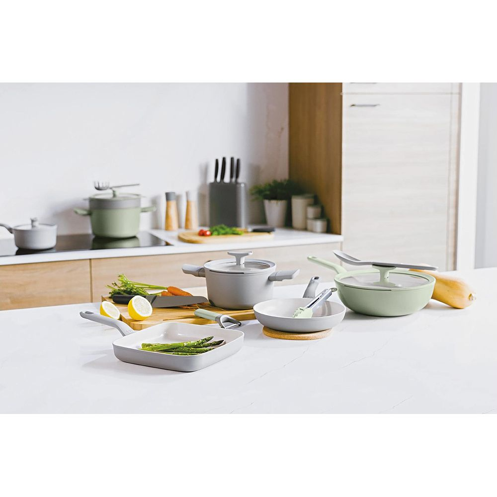 Gray cookware and vegetables arranged on a kitchen counter.