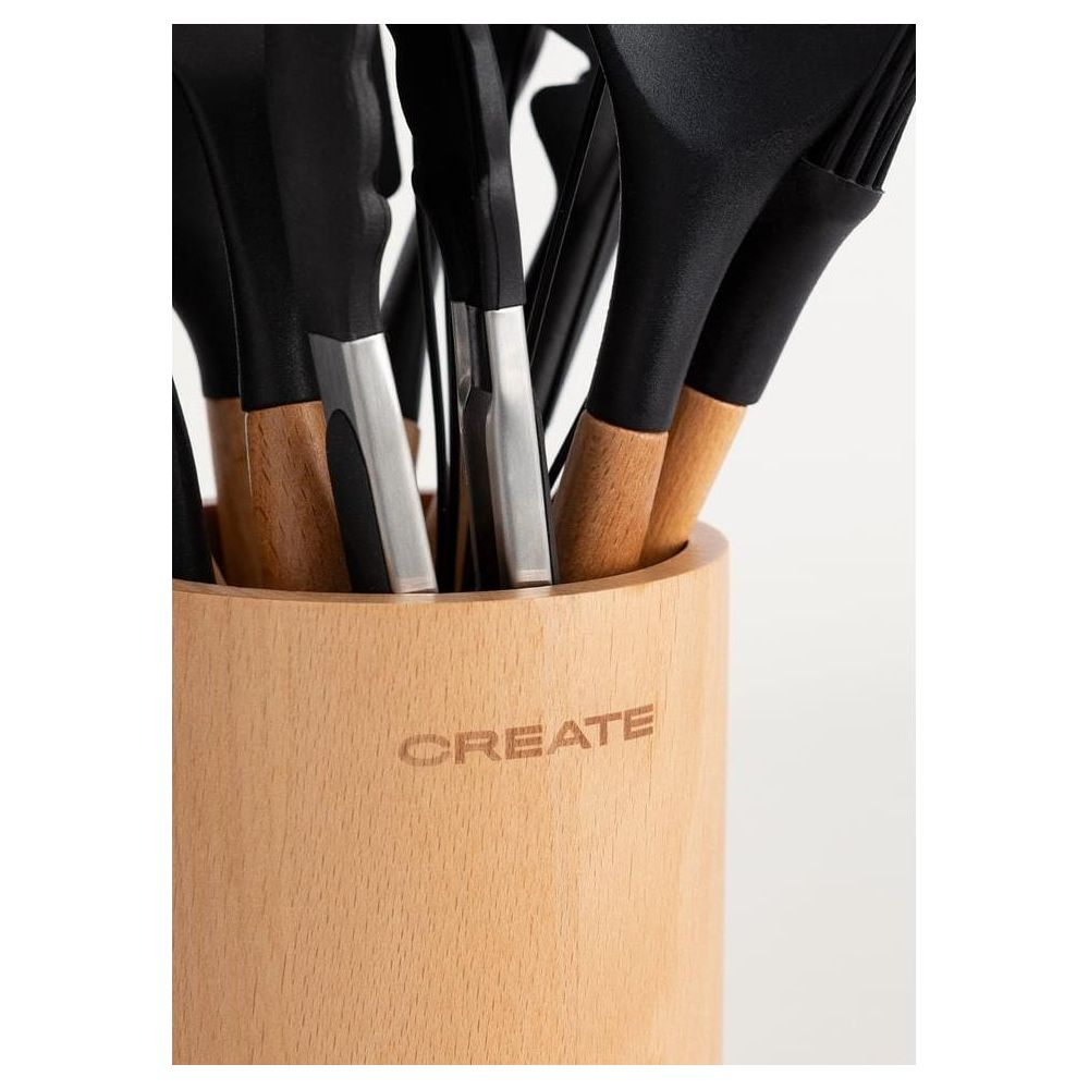 Un soporte de madera con la palabra CREATE grabada, lleno de utensilios de cocina negros con mangos de madera.
