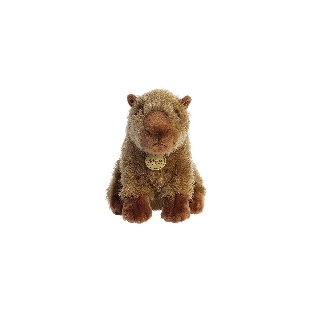 Una capibara di peluche marrone è seduta dritta rivolta in avanti.