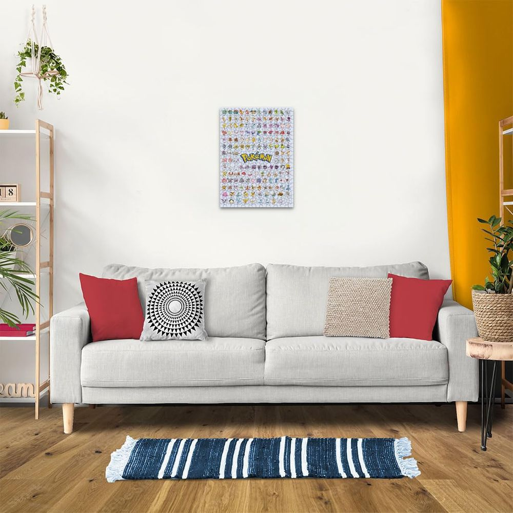 Plakat z postaciami Pokémon wisi nad szarą sofą z poduszkami.