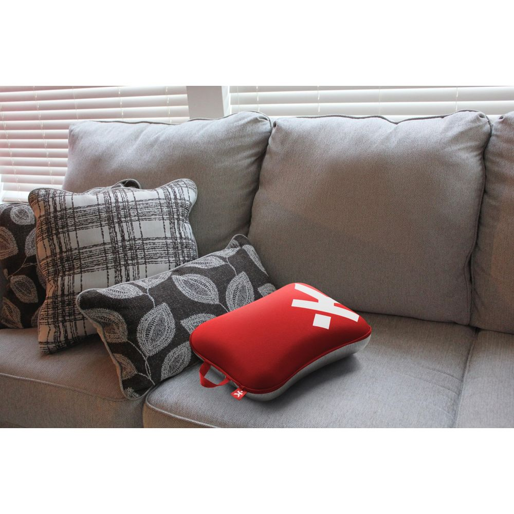 Un coussin rouge avec un "Y" blanc sur un canapé avec d'autres coussins.