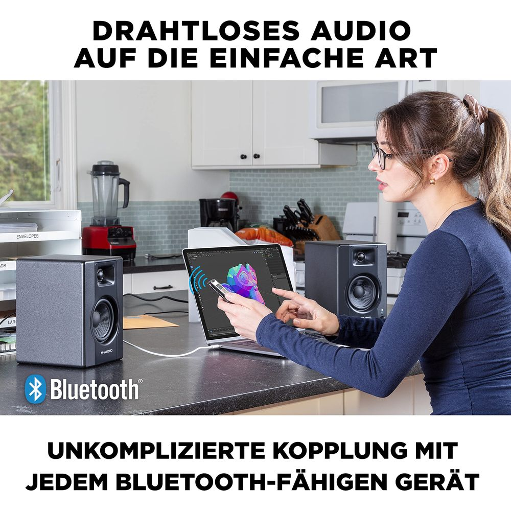 Frau mit Brille bedient Laptop mit Lautsprechern und Bluetooth.