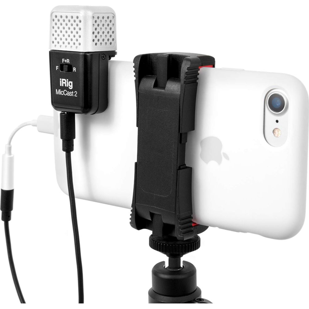 Ein weißes iPhone mit iRig MicCast 2 Mikrofon, das an einem Stativ befestigt ist.