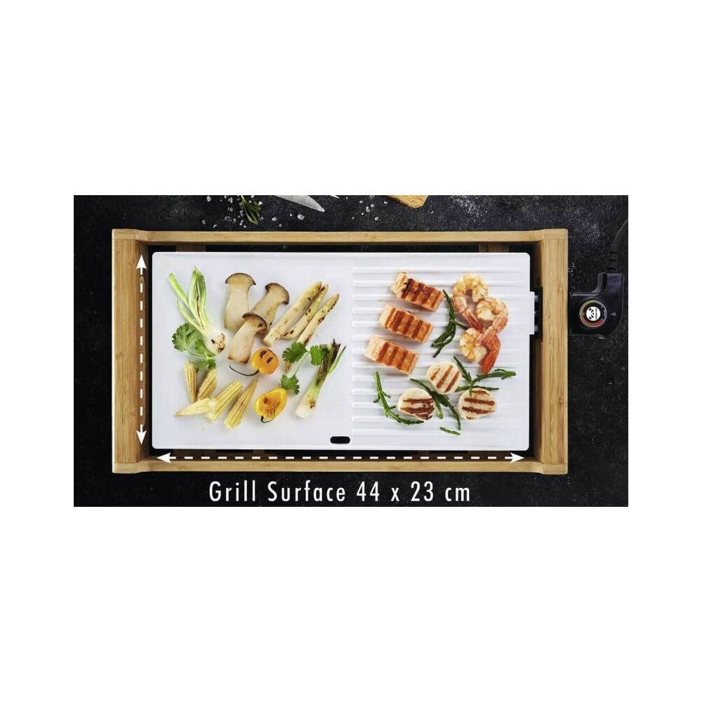 Griglia con salmone, gamberi, funghi, pannocchie e cipollotti su superficie bianca.