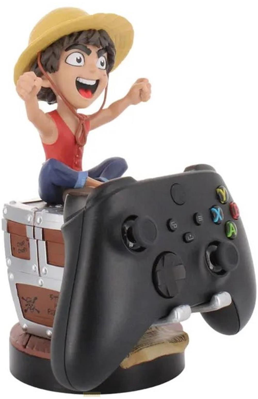 Una figura siede su un forziere che tiene un controller nero.