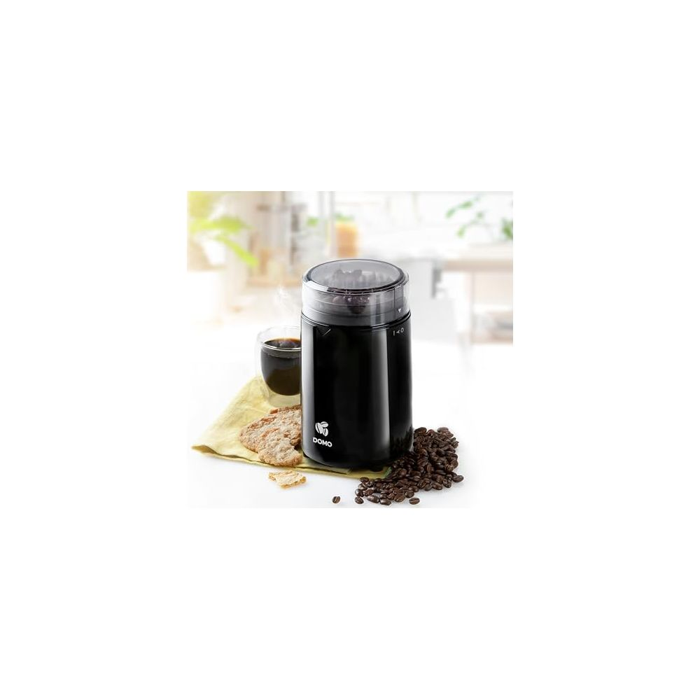 Molinillo de café negro con granos de café, galletas y una taza de café.