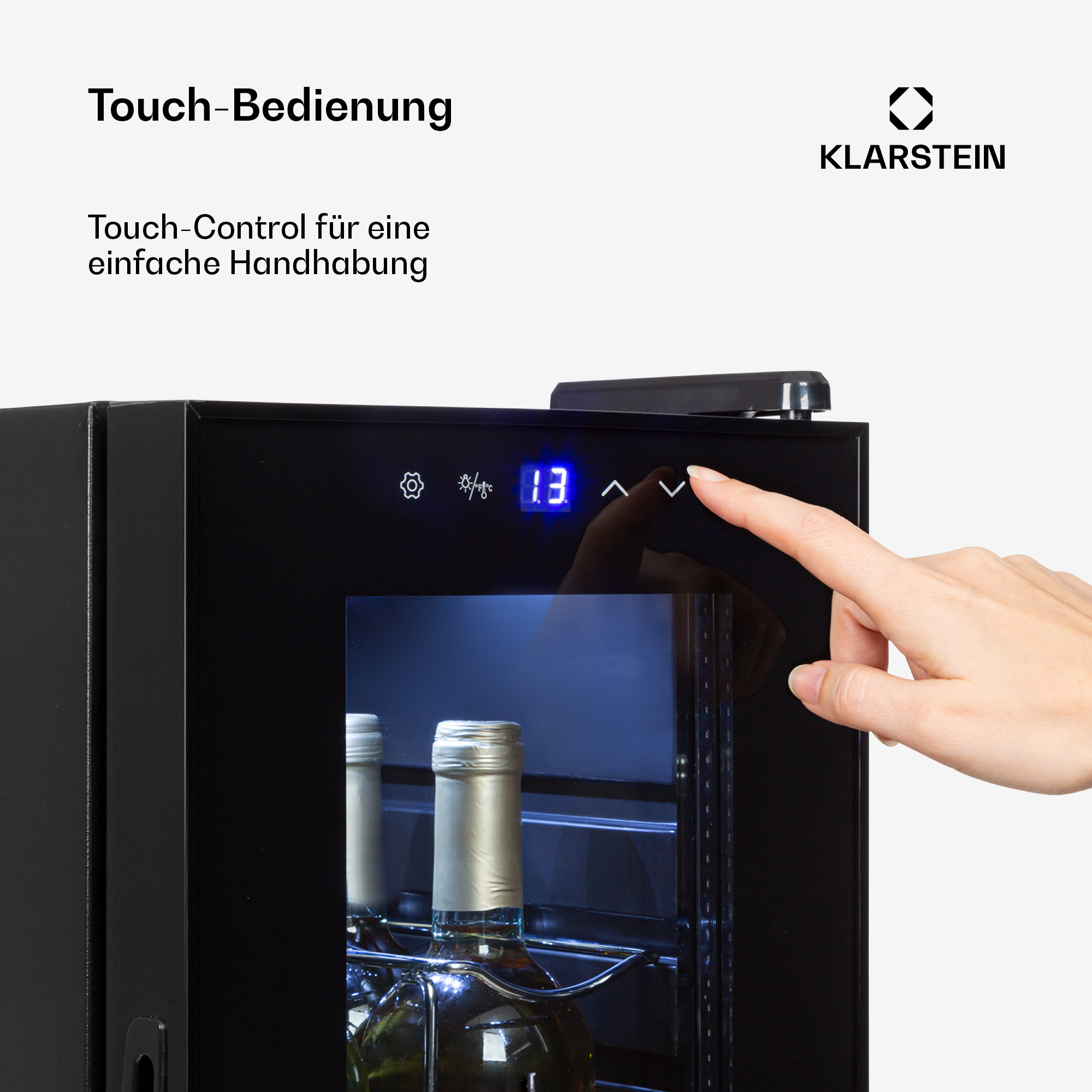 Una mano aziona un display touchscreen su un frigorifero nero con bottiglie di vino all'interno.