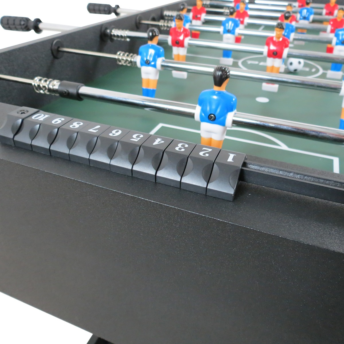 Tafelvoetbalspel met rode en blauwe speelfiguren op groen gras en een scoreteller.