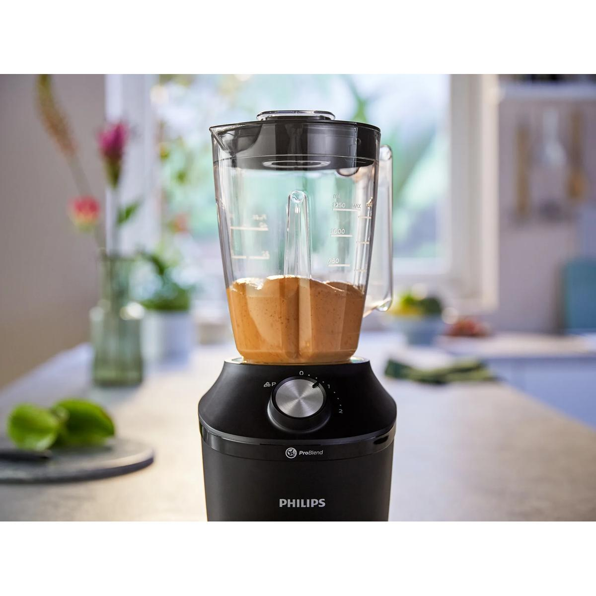 A black Philips blender with brown contents in the jug.