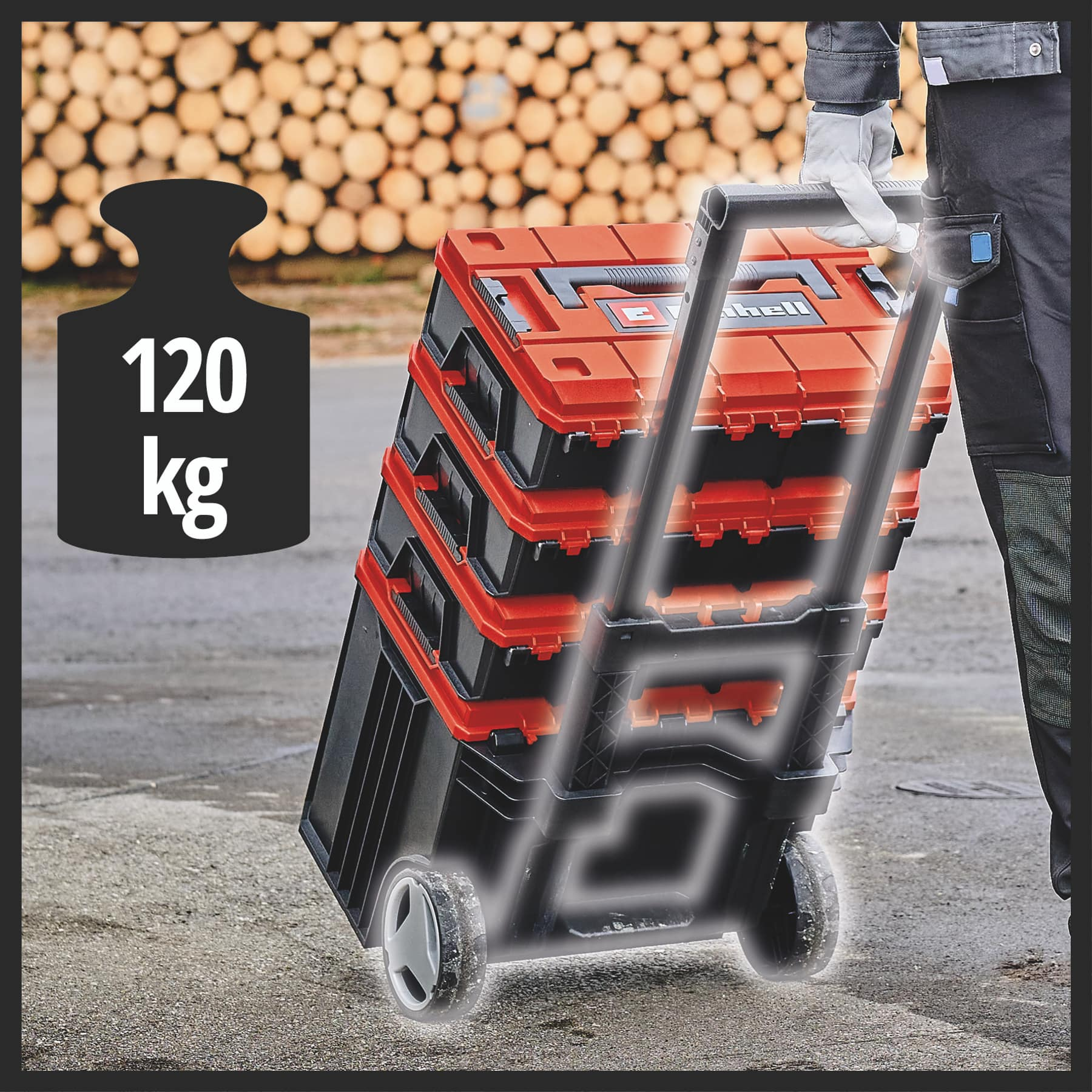 Ein Mann zieht eine orange-schwarze Werkzeugkiste auf Rädern.