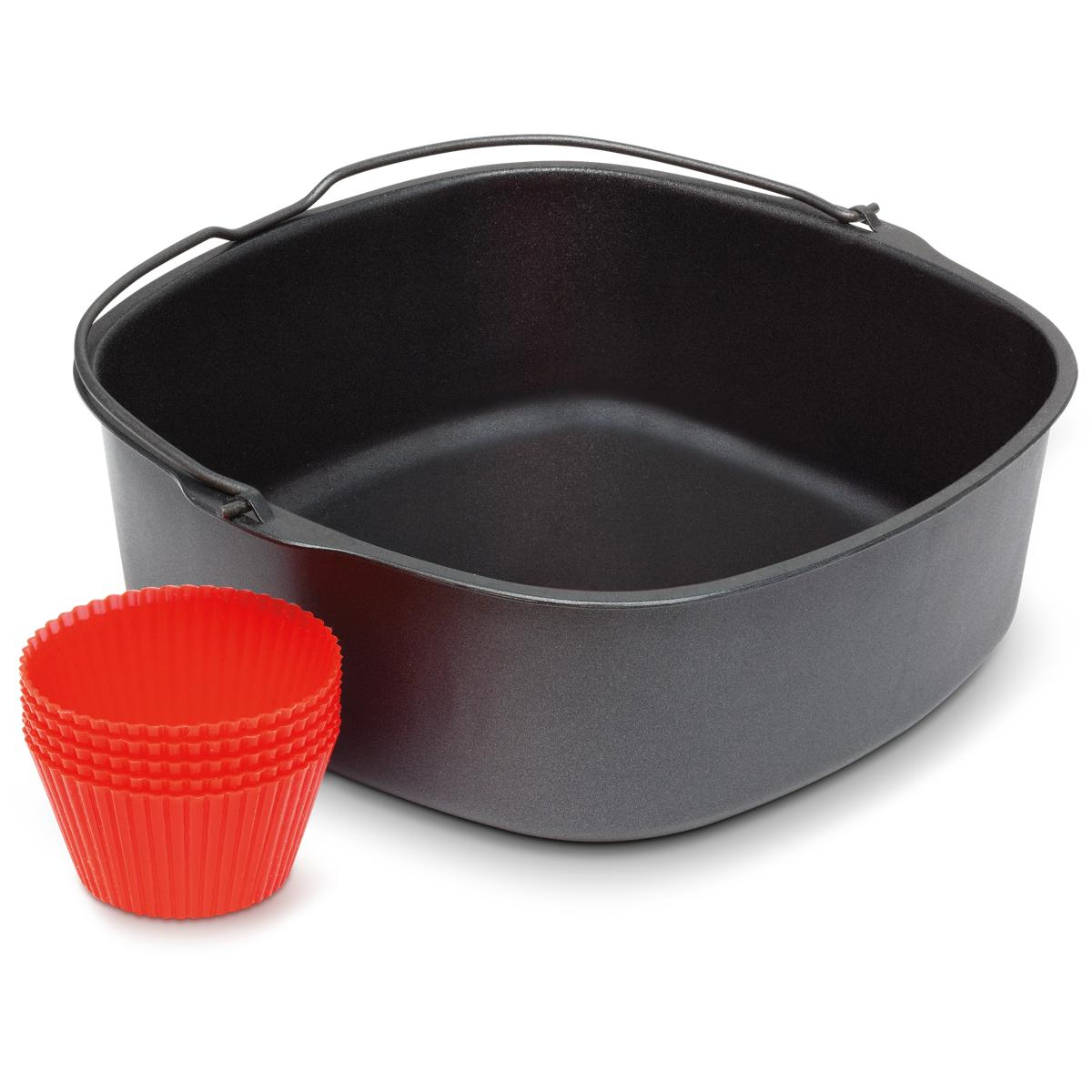 Un panier de friteuse à air gris avec une pile de moules à muffins en silicone rouges à côté.