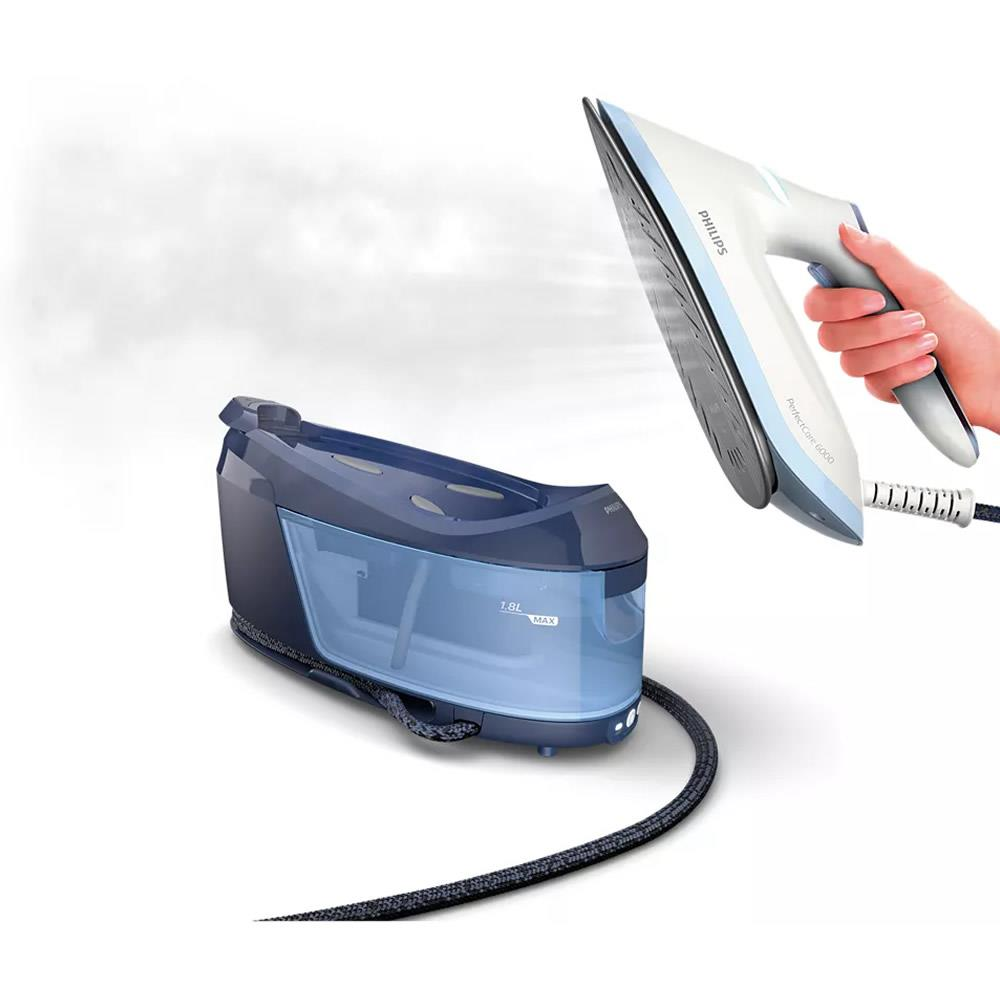 Bir el, mavi su haznesinin yanında buhar çıkaran bir Philips ütüyü tutuyor.