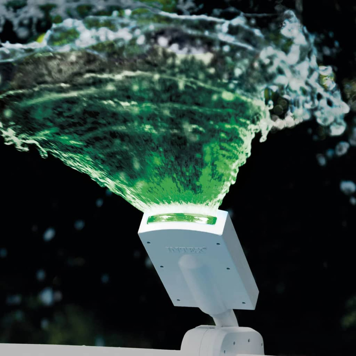 Białe światło rzutuje zieloną wodę do góry, tworząc efekt fontanny.