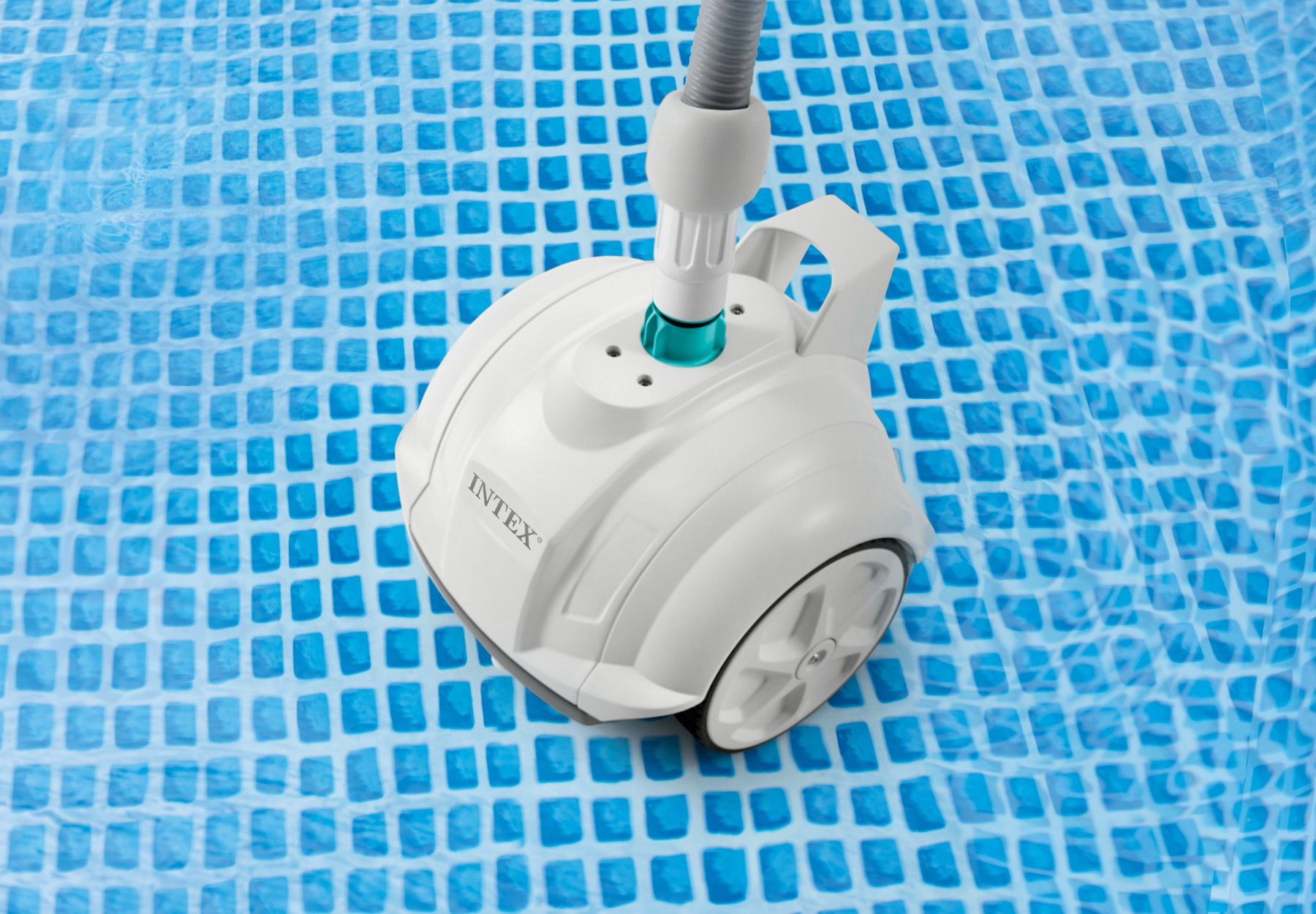 Un pulitore per piscine bianco con ruote galleggia sull'acqua blu a scacchi.