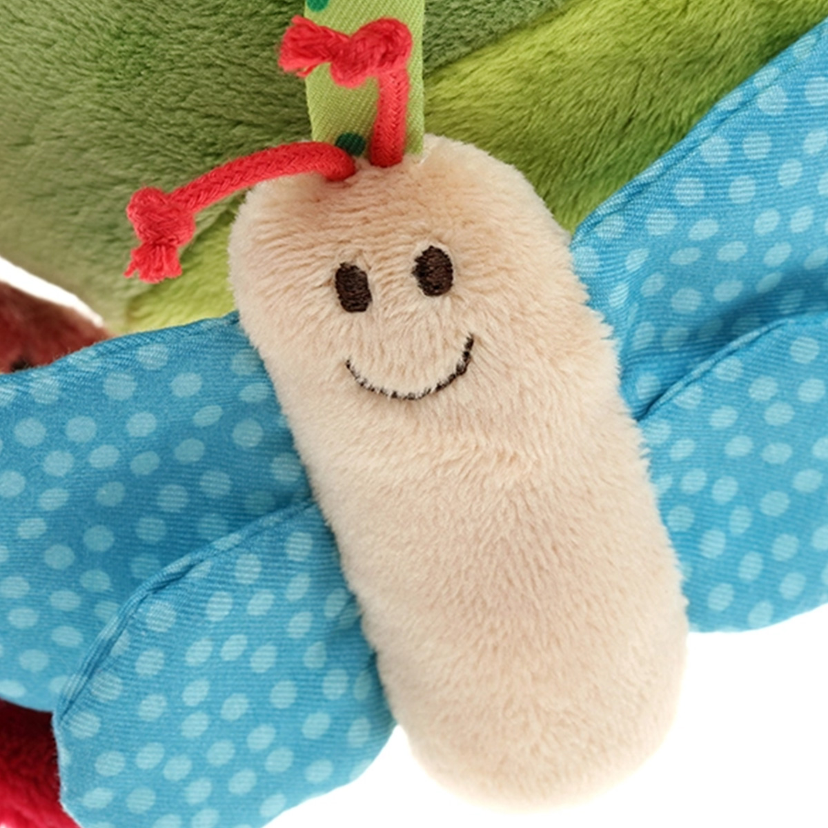 Un insetto beige chiaro e soffice con faccia sorridente e ali blu a pois bianchi.
