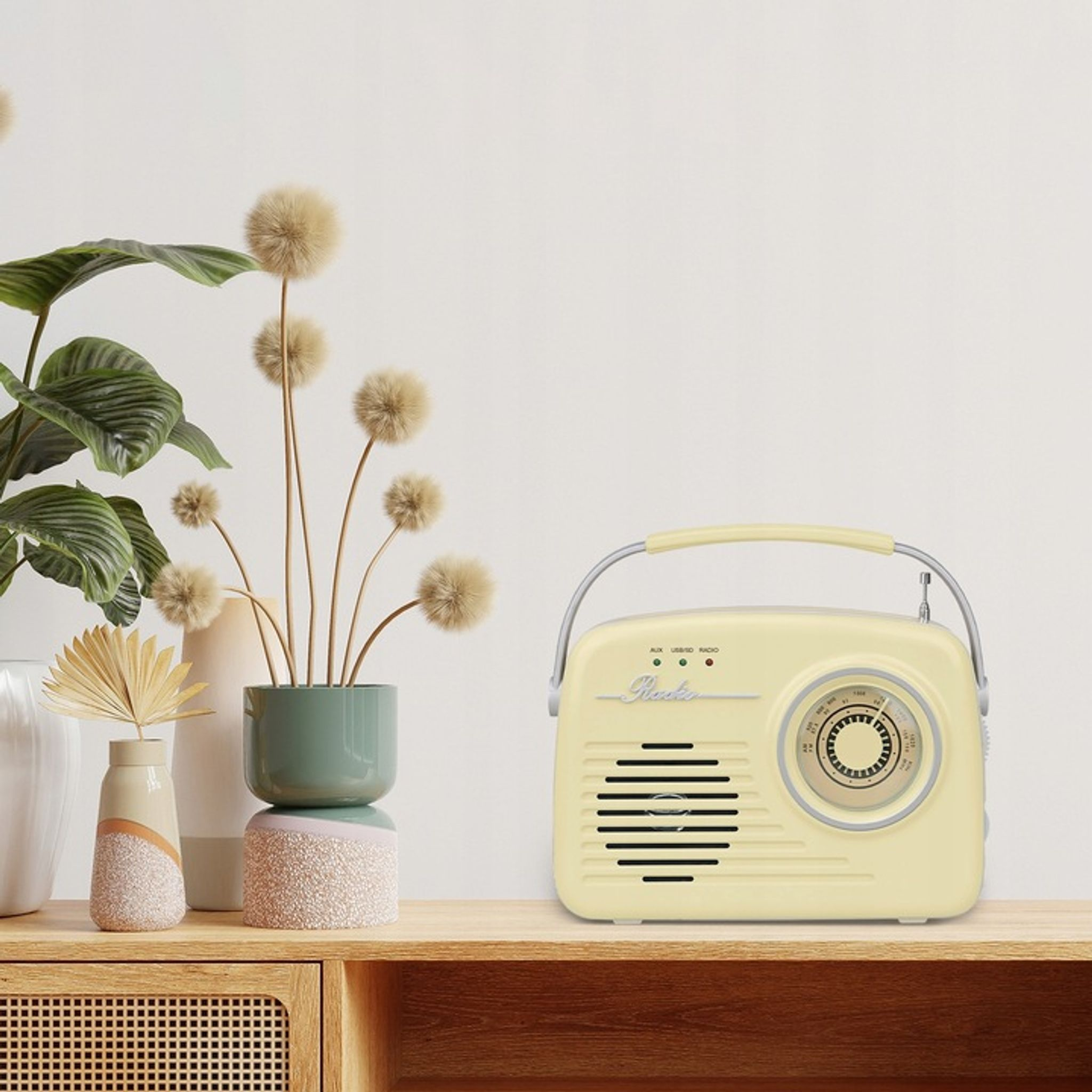 Kremowe radio w stylu retro stoi na drewnianej szafce obok roślin.