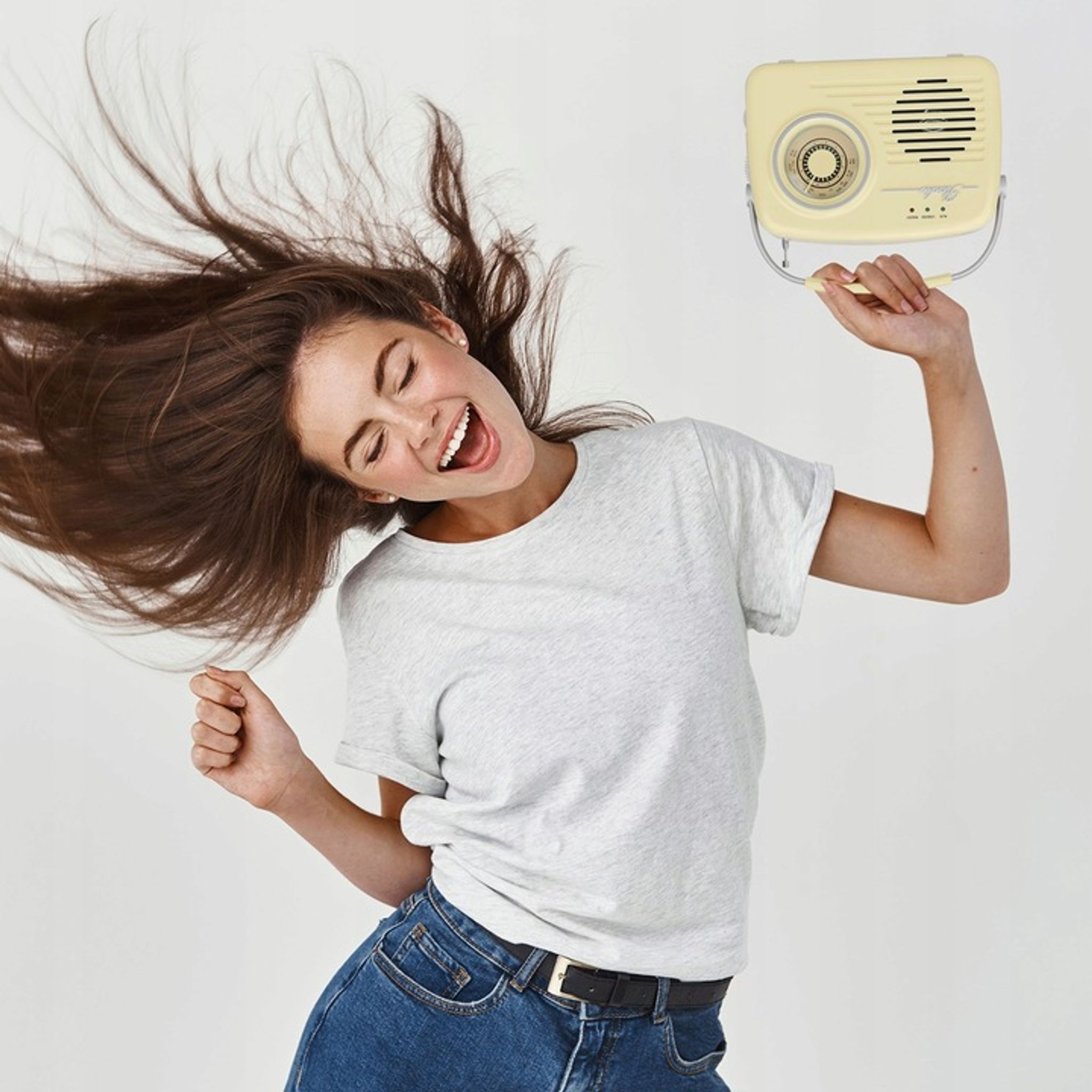 Kobieta z otwartymi ustami i długimi włosami trzyma żółte radio.