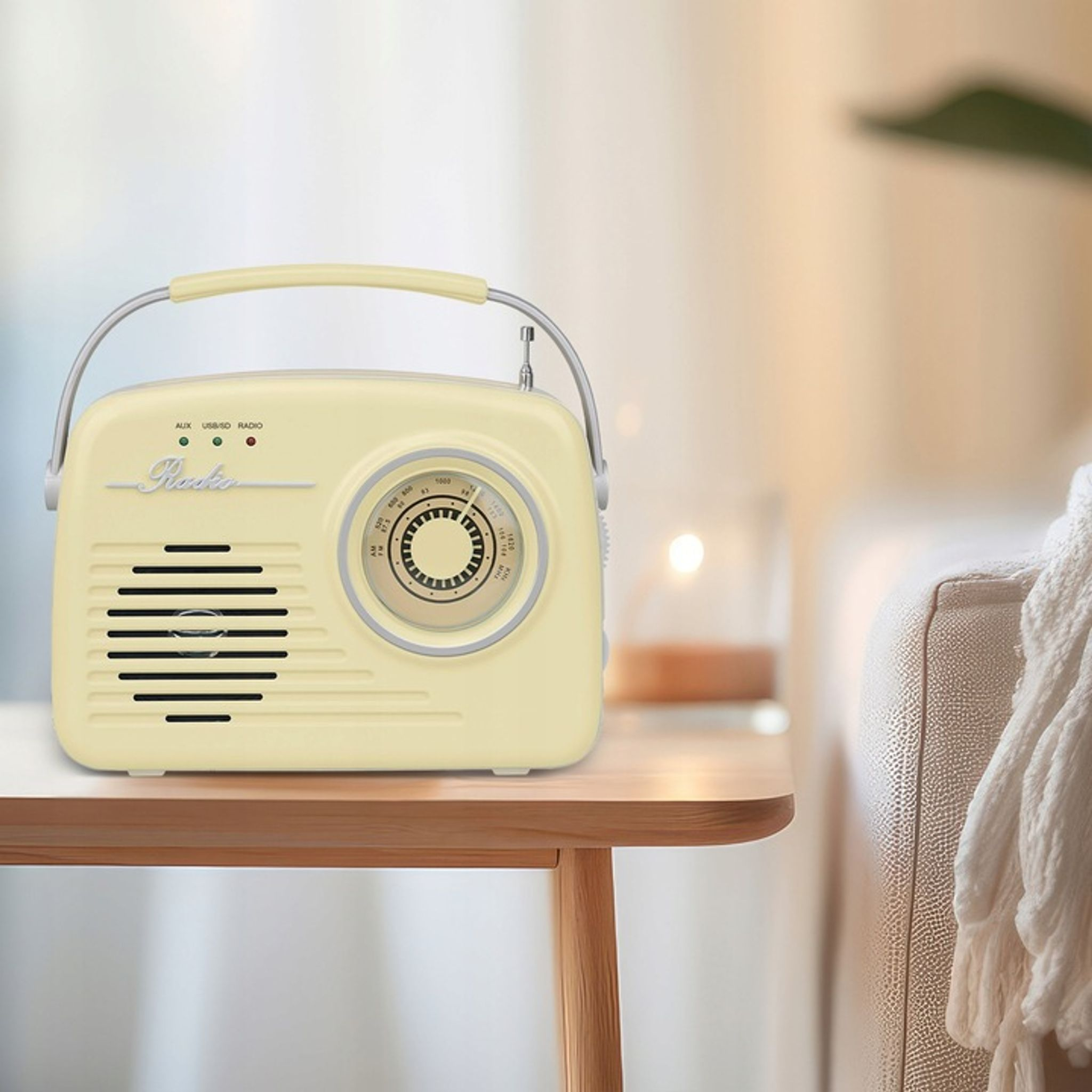 Kremowe radio w stylu retro z uchwytem i pokrętłem na drewnianym stole.