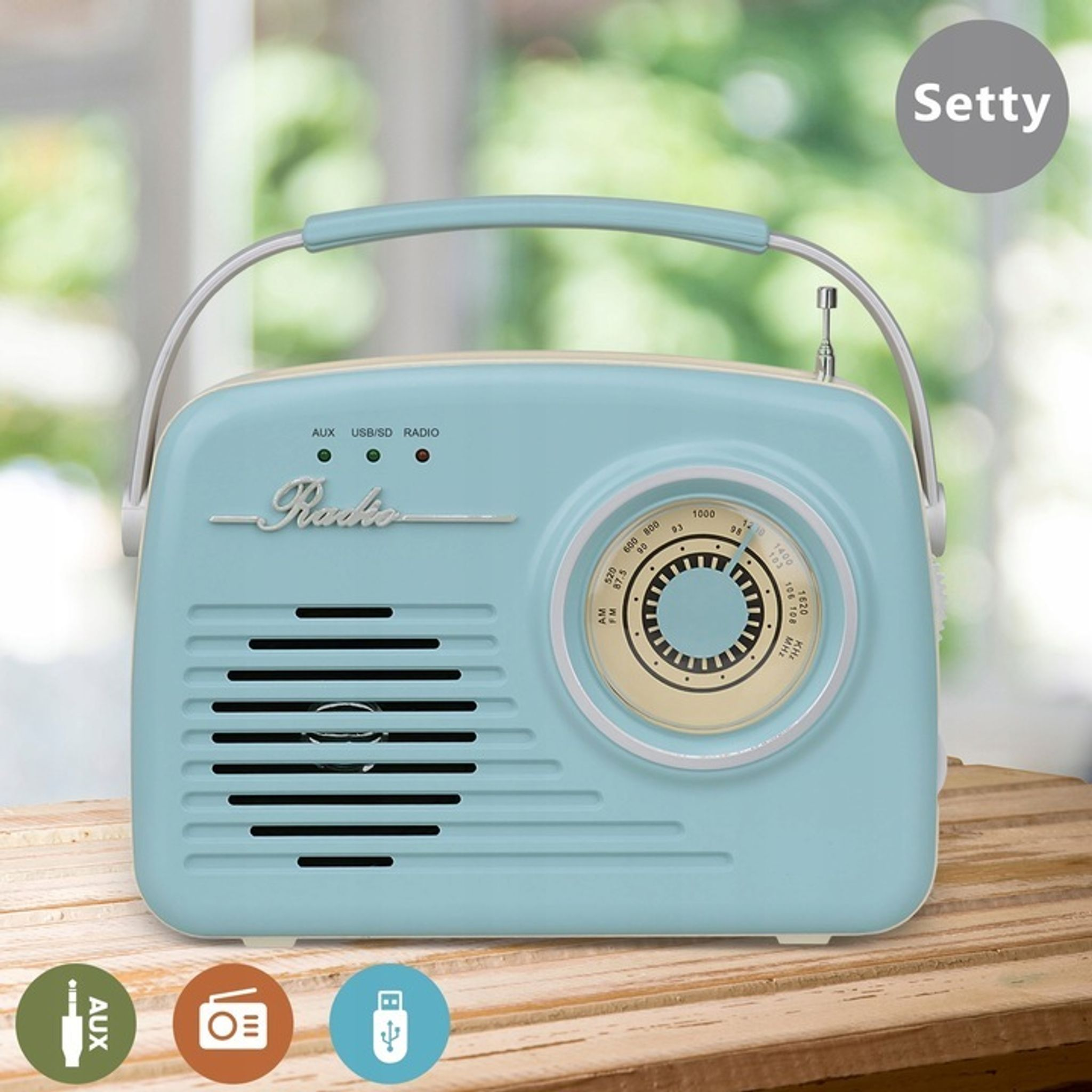 Jasnoniebieskie radio retro z uchwytem i srebrnymi akcentami stoi na drewnianym stole.