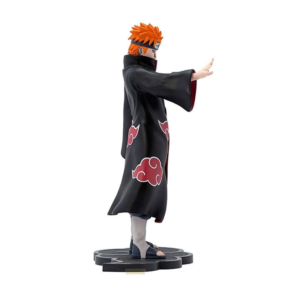 Figur eines Mannes in schwarzem Mantel mit roten Wolken, orangefarbenem Haar, auf einem Podest.