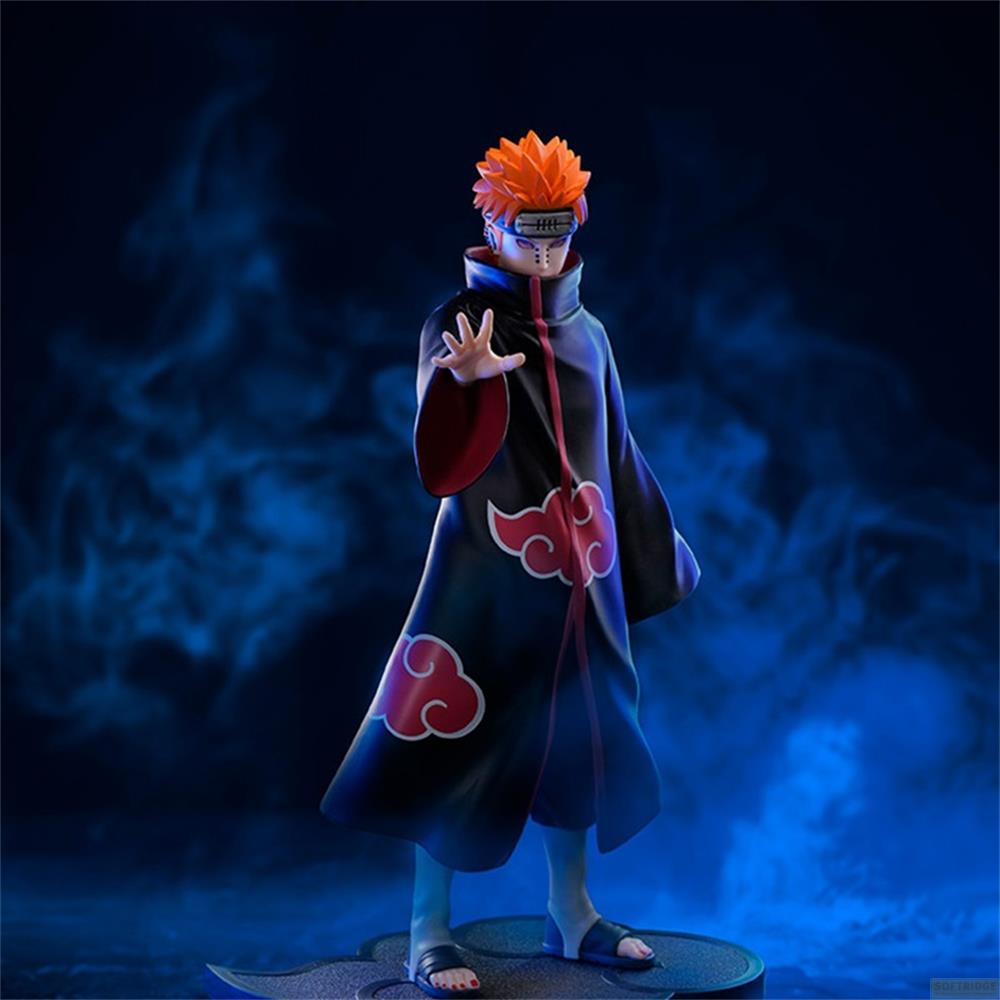 Eine Figur mit orangefarbenem Haar trägt einen schwarzen Umhang mit roten Wolken. Blaue Rauchwolken im Hintergrund.