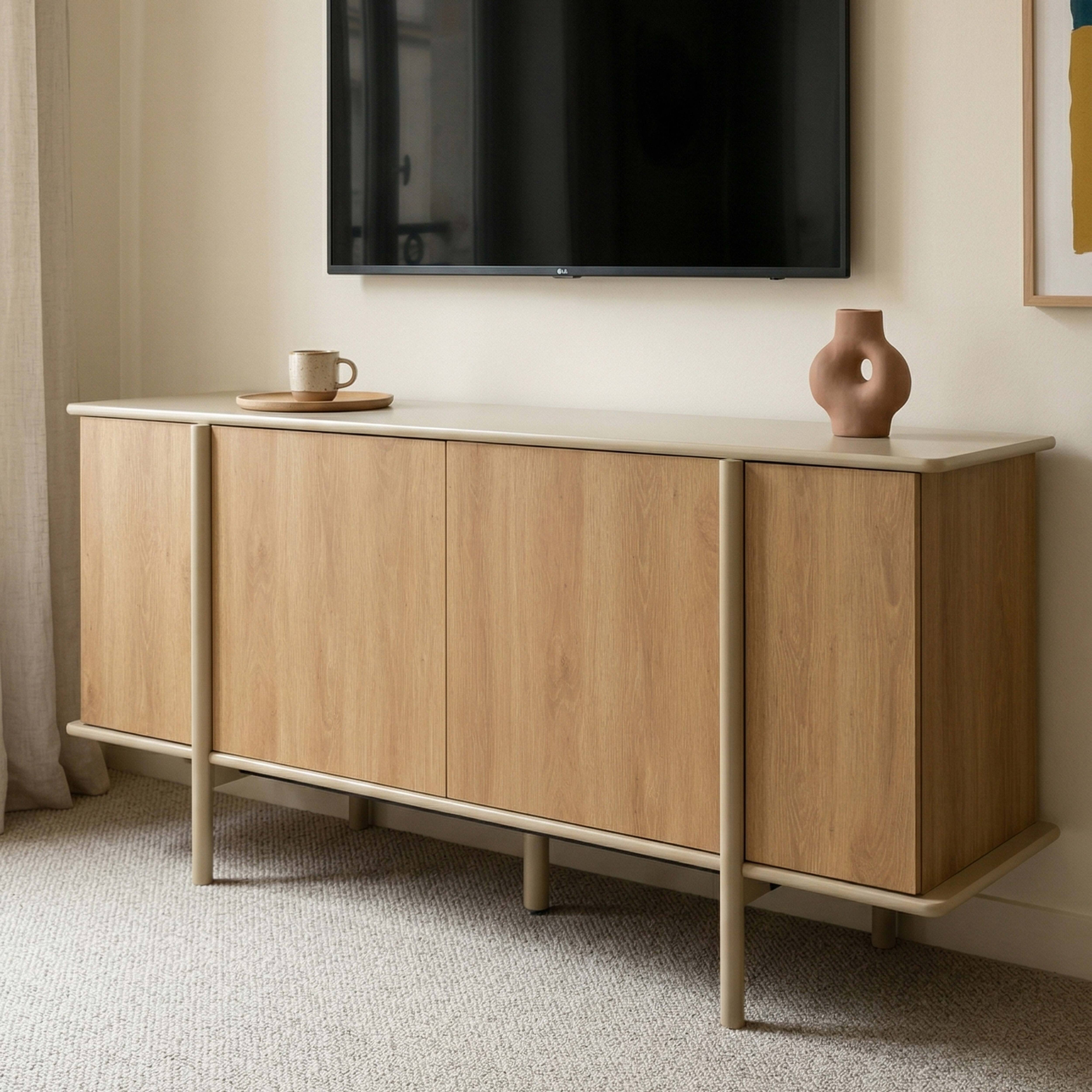 Ein hellbraunes Sideboard mit vier Türen und einem Fernseher darüber.