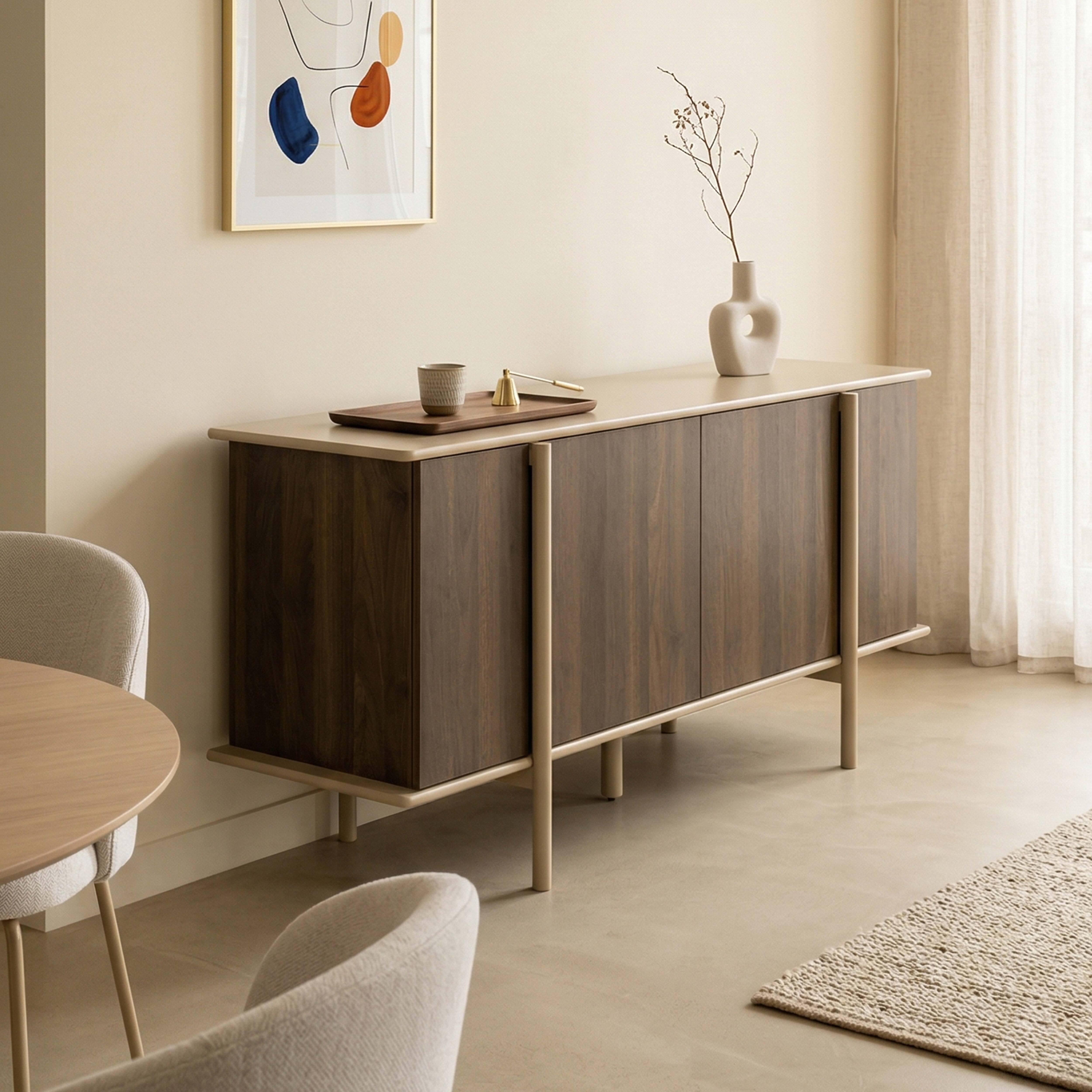 Ein dunkles Sideboard mit hellen Beinen, darauf eine Vase und Tablett. Sitzmöbel und Tisch daneben.