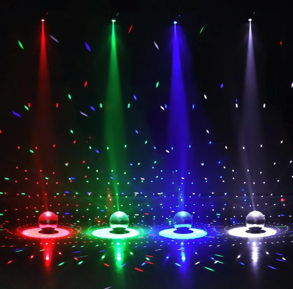 Vier Discokugeln mit roten, grünen, blauen und weißen Lichtstrahlen auf dunklem Hintergrund.