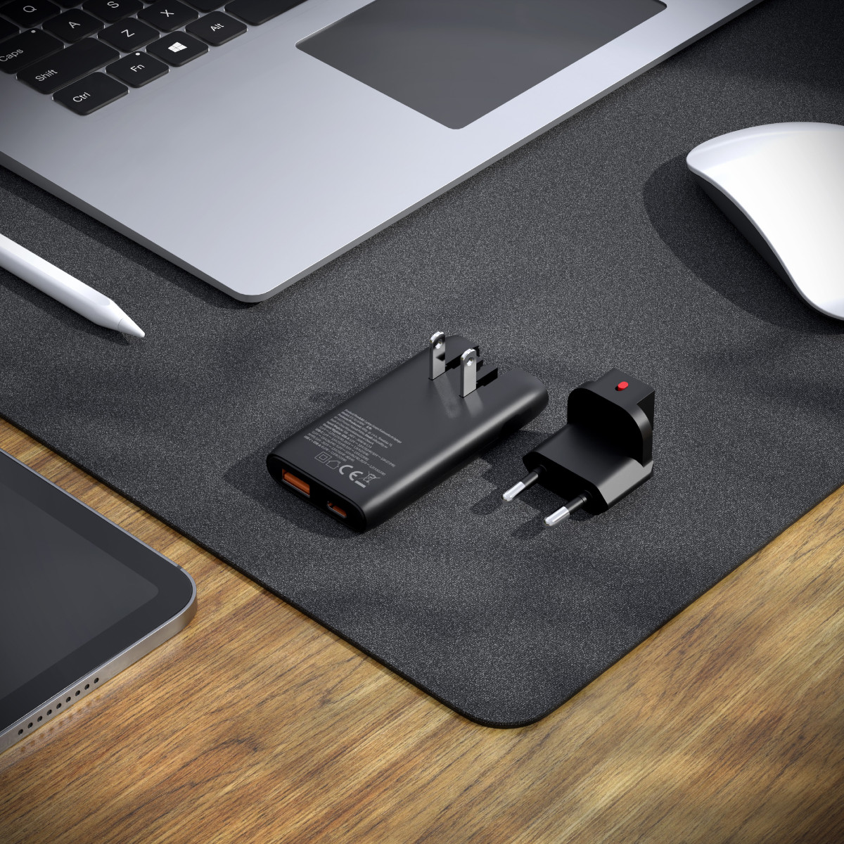Un caricabatterie nero con due porte USB e un adattatore di alimentazione su un tappetino.