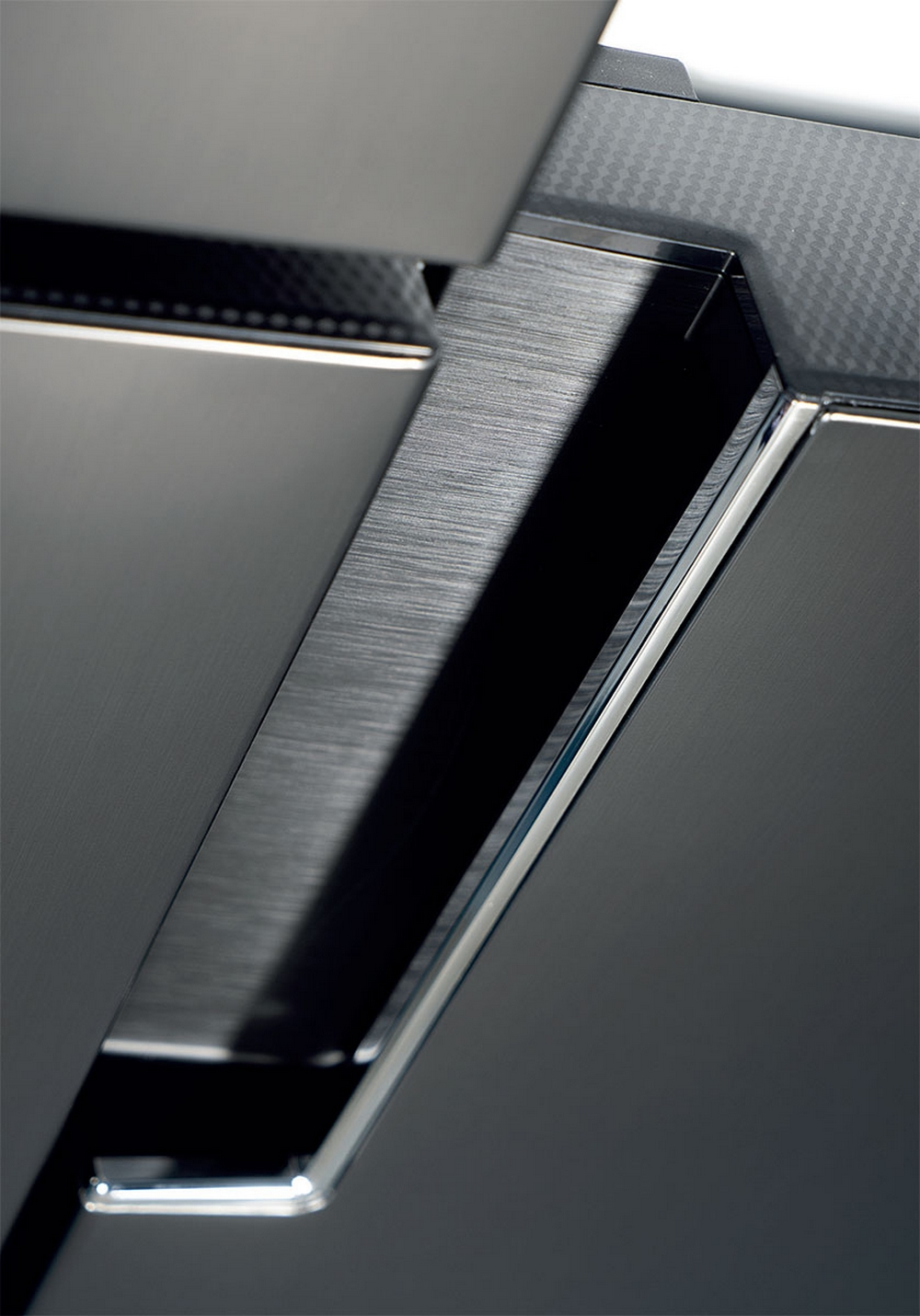 Primo piano di superfici metalliche scure spazzolate con accenti argentati.