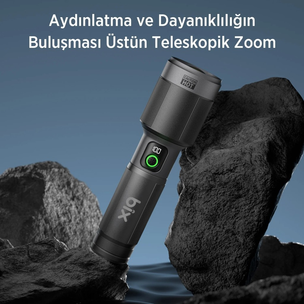 Koyu renkli "bix" logolu el feneri, kayaların üzerinde, mavi gökyüzü.