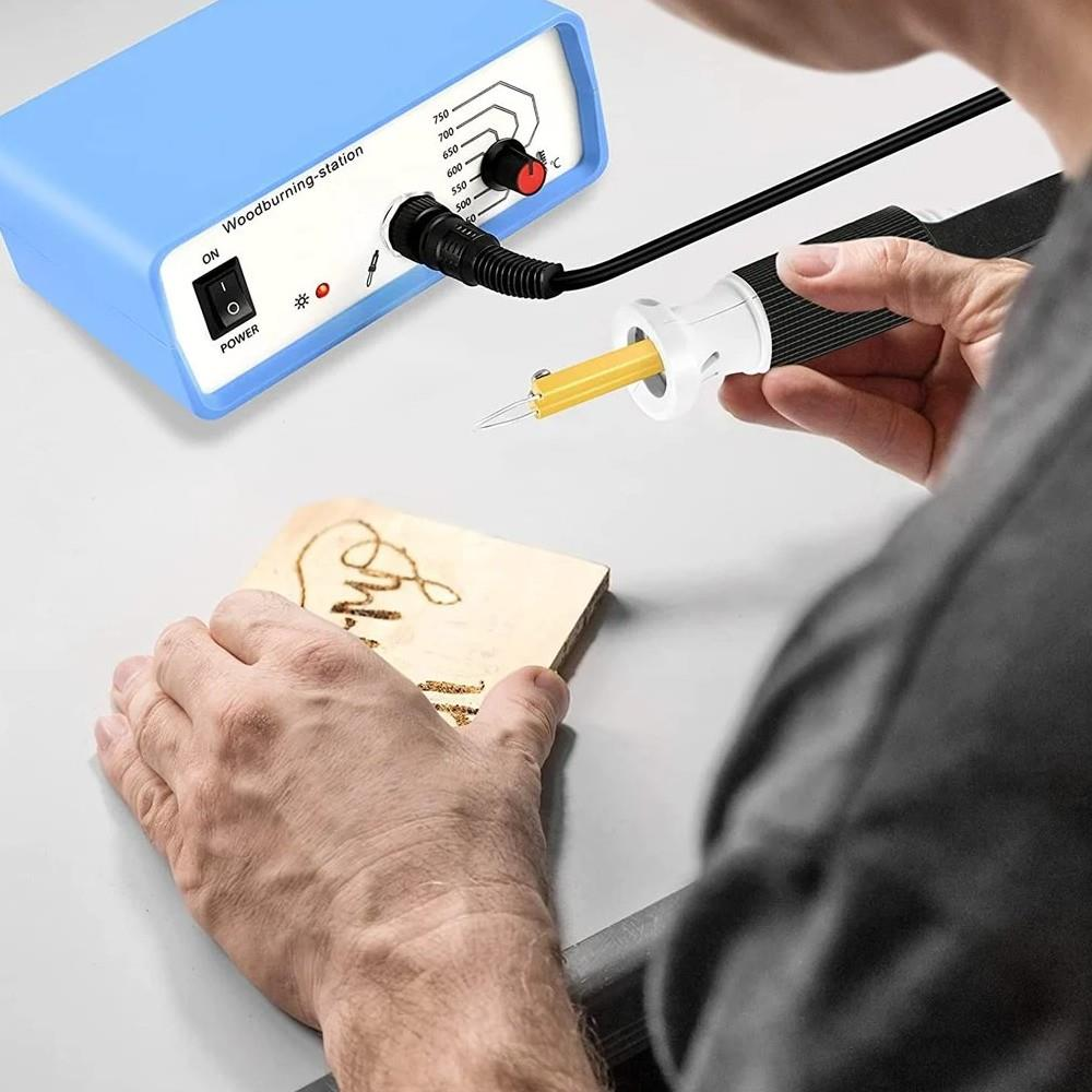 Bir kişi ahşap üzerine desen yakmak için ahşap yakma istasyonu kullanıyor.
