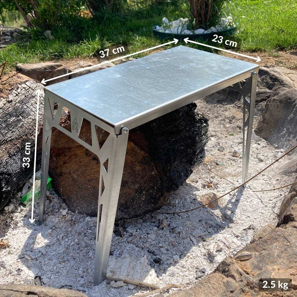 Yanmış bir kütüğün üzerinde ateş çukurunda küçük bir metal masa duruyor.