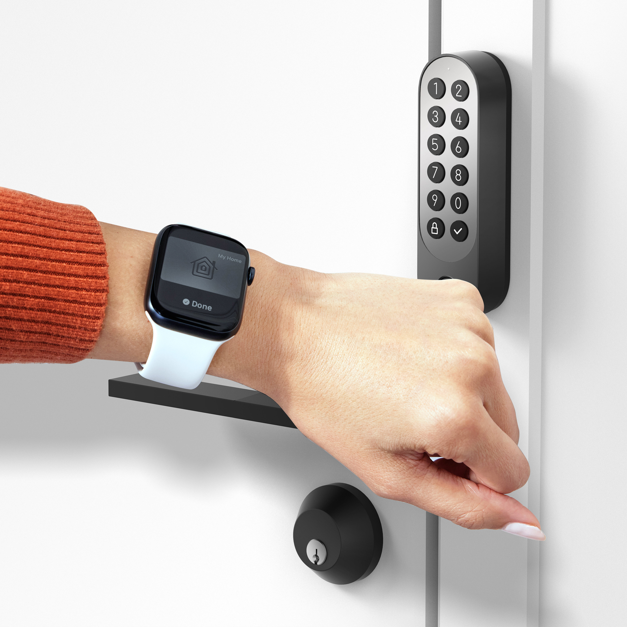 Hand mit Smartwatch am weißen Türschloss mit Ziffernblock.