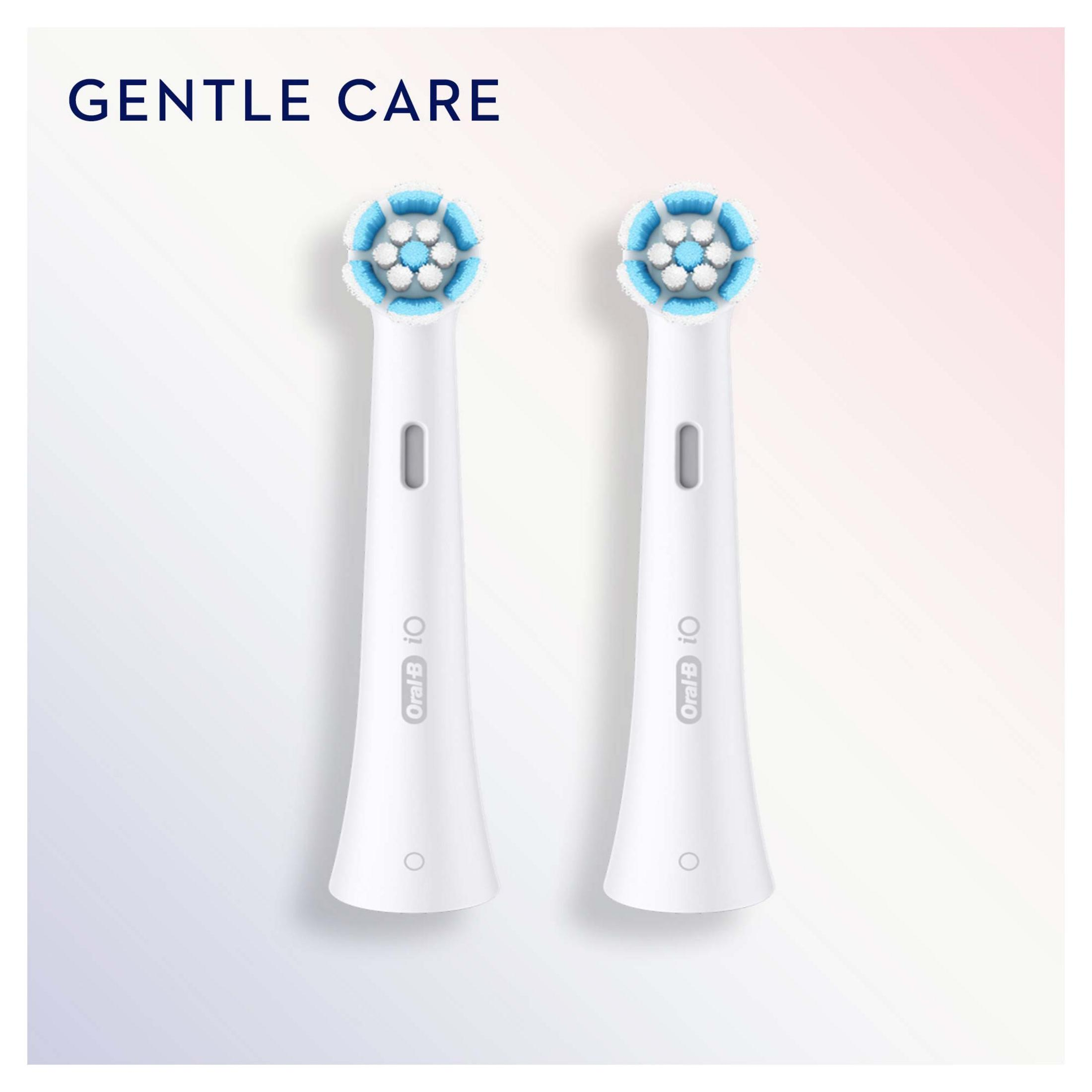 Dwie białe główki szczoteczki Oral-B iO z niebieskim włosiem na jasnym tle.