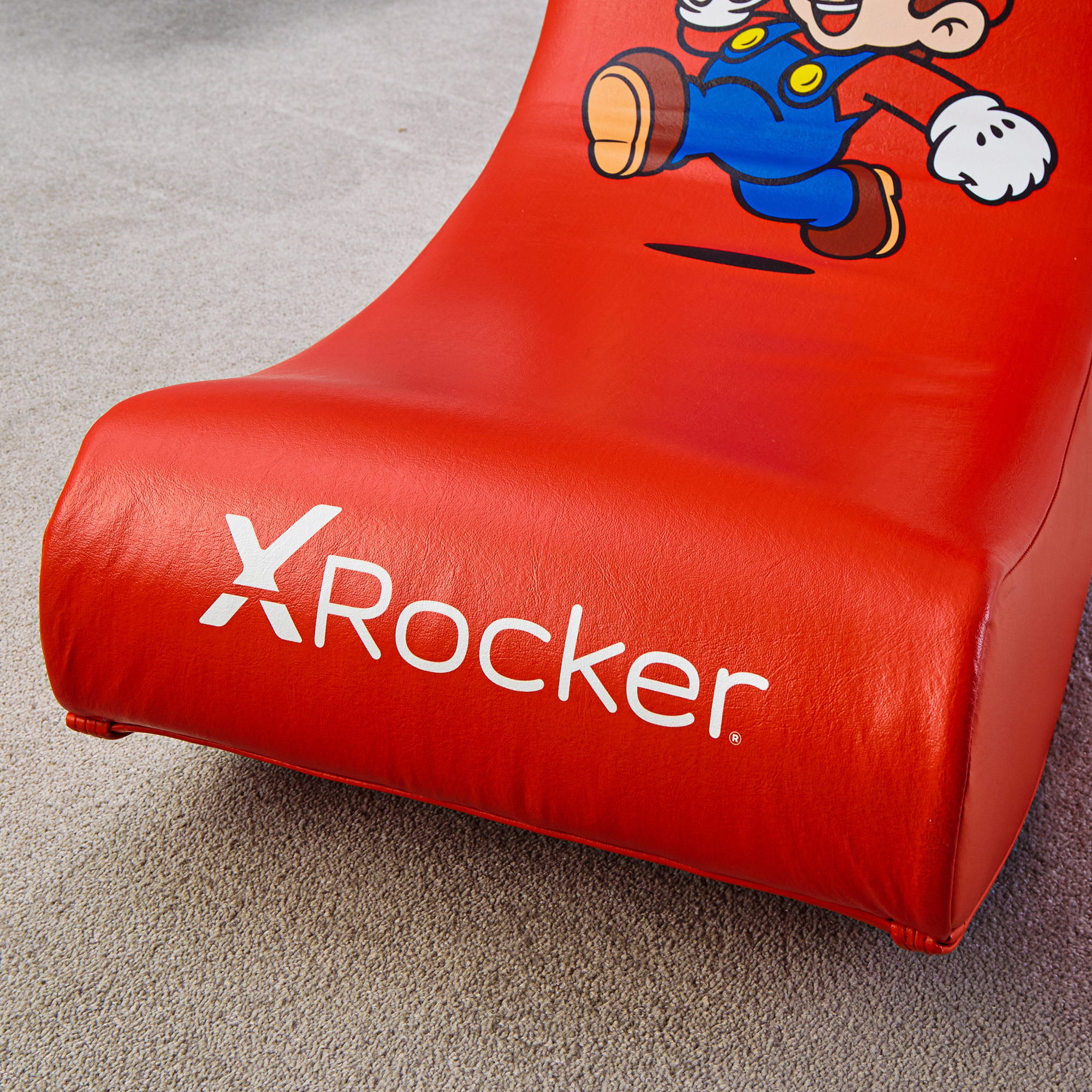 Ein roter X-Rocker-Gaming-Stuhl mit Mario-Aufdruck auf Teppich.