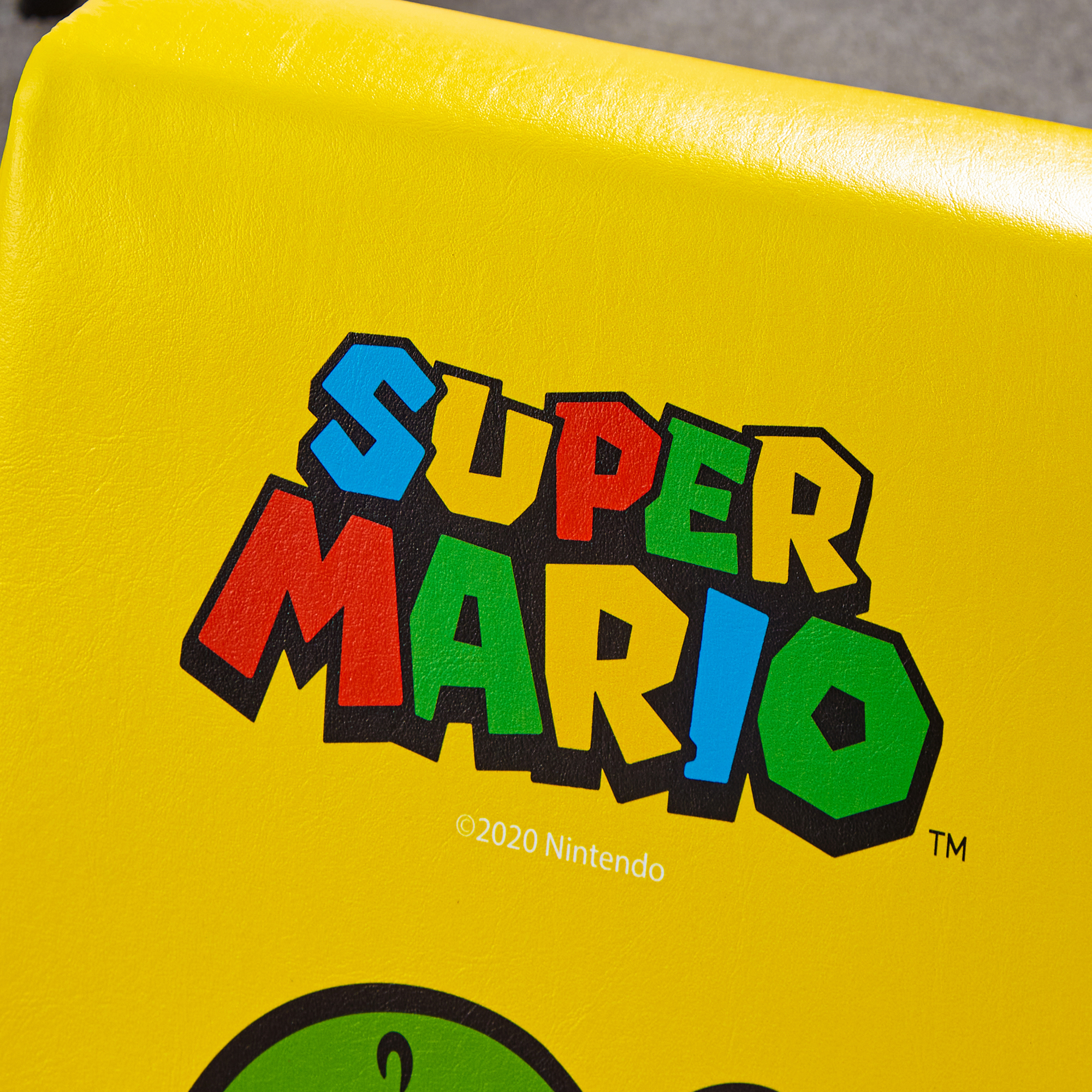 Het Super Mario logo in kleurrijke letters op een gele achtergrond.