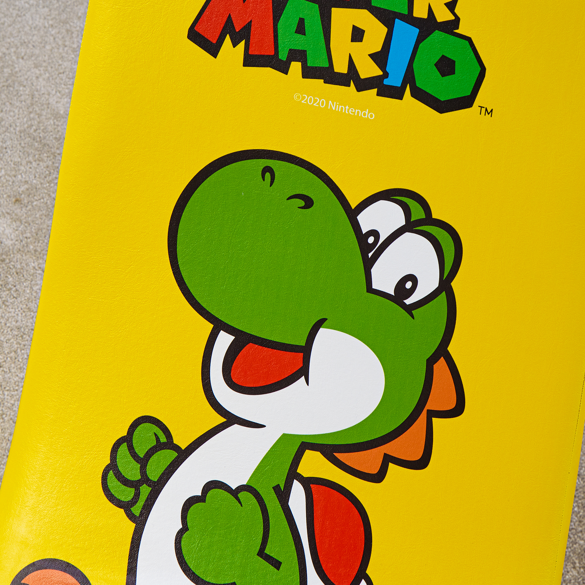 Gele achtergrond met Yoshi en het Mario-logo. ©2020 Nintendo.
