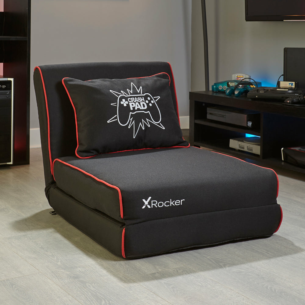 Ein schwarzer Gaming-Stuhl mit roter Zierleiste, Kissen mit Gamepad und X Rocker-Logo.