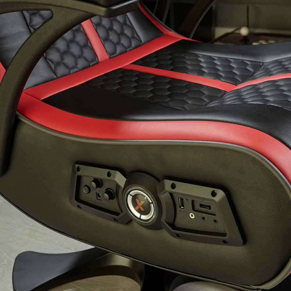 Schwarzer und roter Gaming-Stuhl mit Bedienelementen, USB und Audioanschlüssen an der Seite.