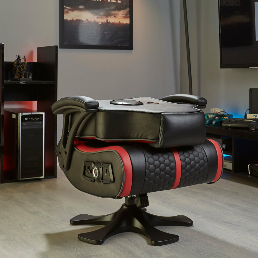 Ein schwarzer Gaming-Stuhl mit roten Akzenten steht auf einem Holzboden.