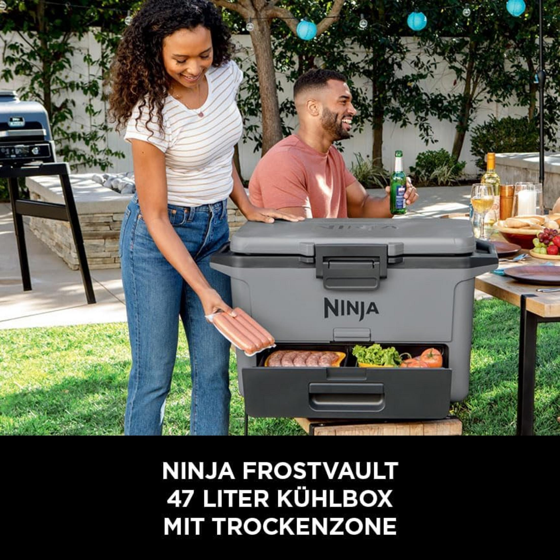 Homme et femme dehors avec une glacière grise. Femme tient des saucisses. Homme boit une bière.