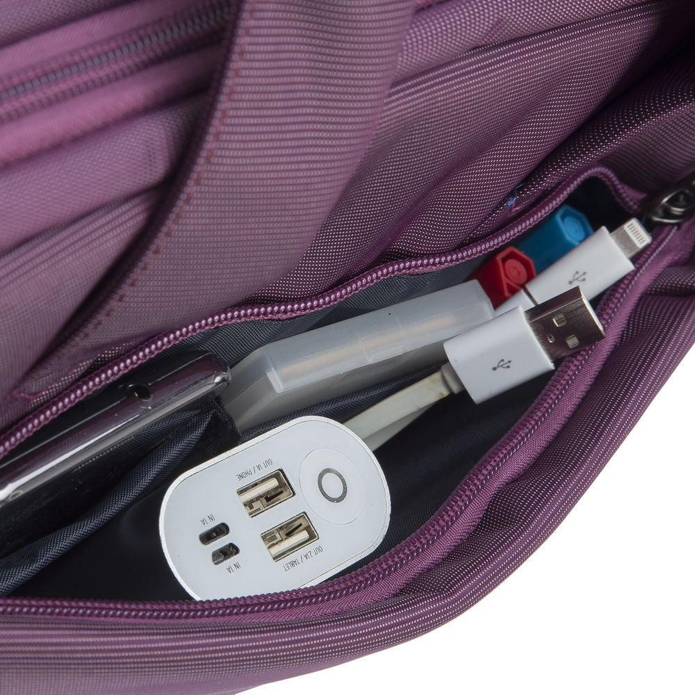 Una borsa viola con cavi di ricarica, power bank e penne all'interno.