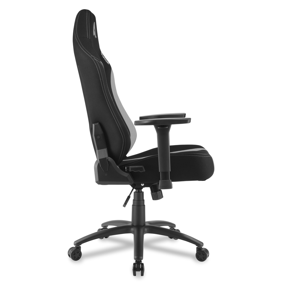 Silla gamer negra con acento gris y costuras blancas, vista lateral.