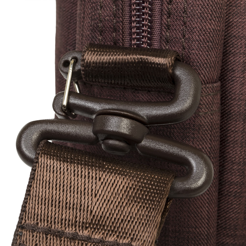Gros plan d'une sangle de sac marron et boucle en plastique marron foncé avec anneau en D.