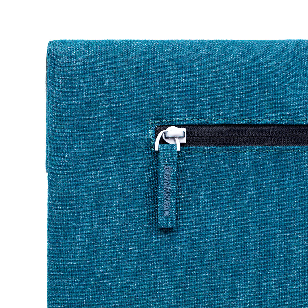 Ein blauer Stoffbeutel mit einem schwarzen Reißverschluss und einem silbernen Zipper.