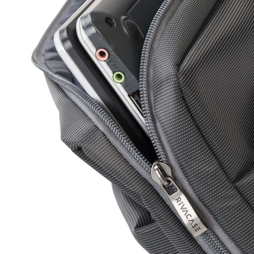 Close-up of a gray RIVACASE bag, with a laptop and ports visible.