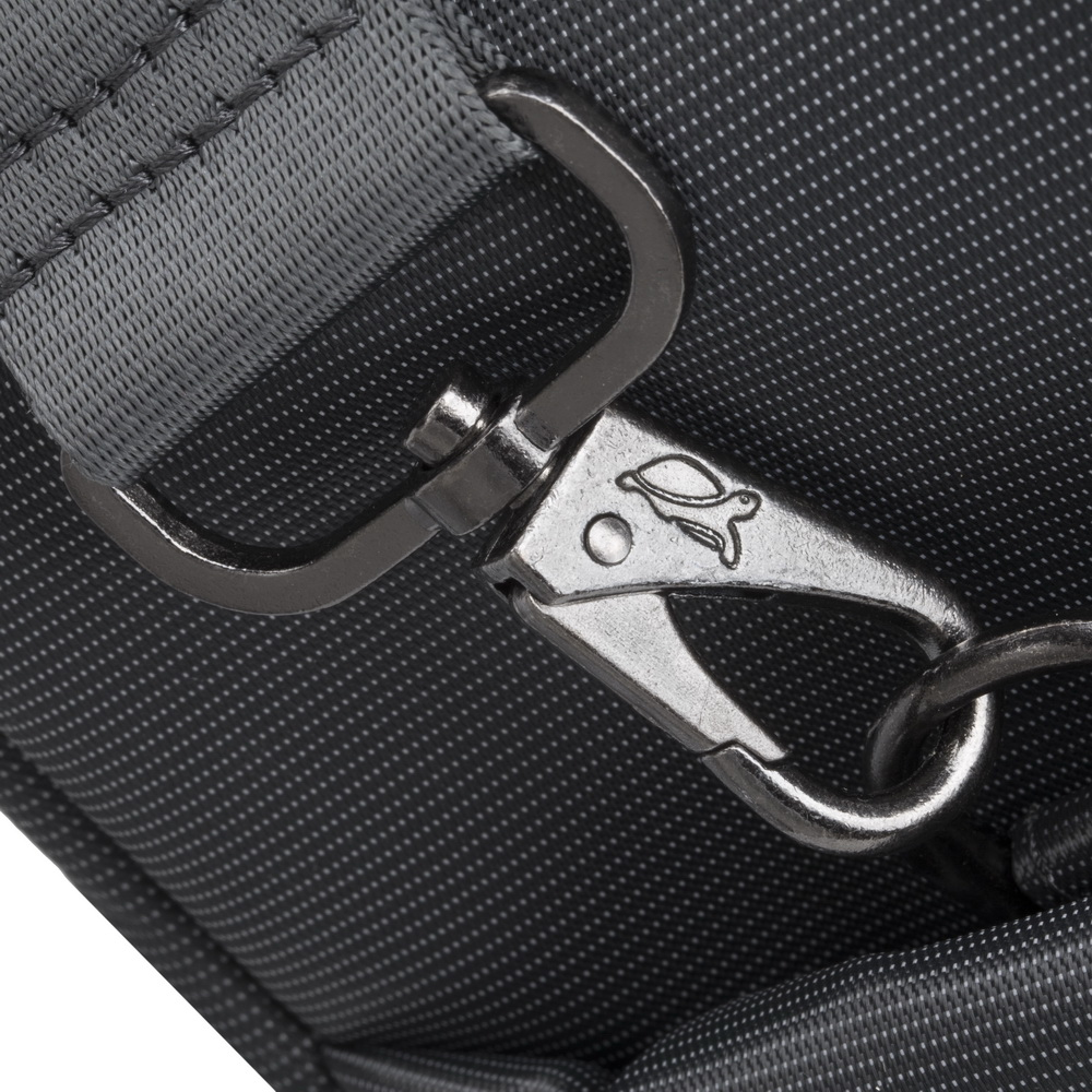A silver-colored swivel clasp with a turtle imprint attached to gray fabric.