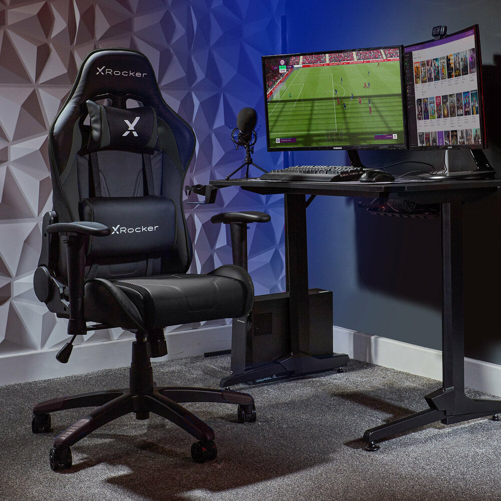 Ein schwarzer Gaming-Stuhl und Schreibtisch mit zwei Monitoren, Mikrofon und Computerturm.
